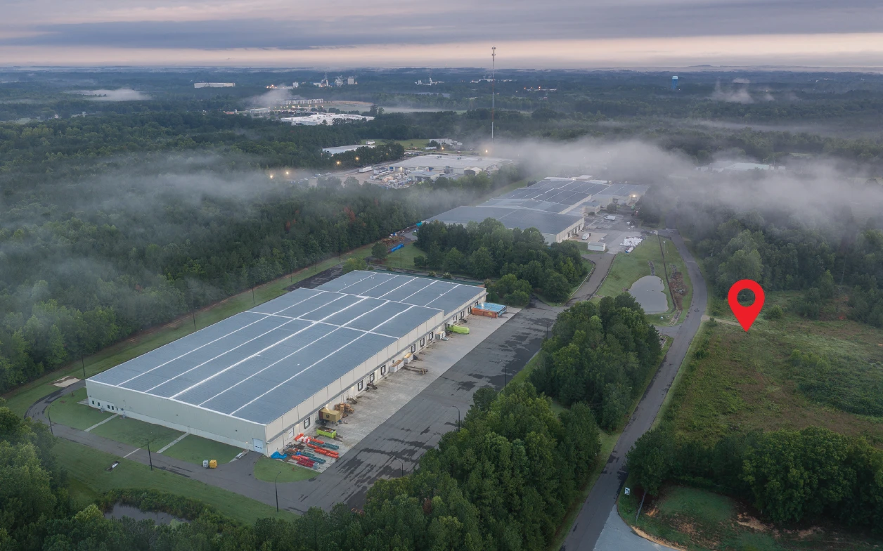 Aerial at dawn of the 105 Enterprise Court site, marked with a red pin on Enterprise Court, beside the business park's industrial buildings with fog lifting over the woods