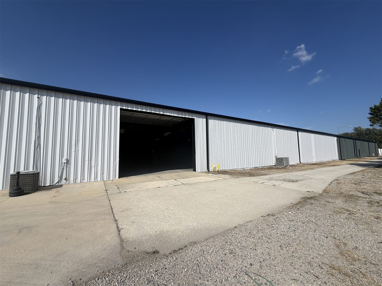 Oversized drive-in opening on a white metal warehouse at 4734 Potato House Court, with a concrete apron in front
