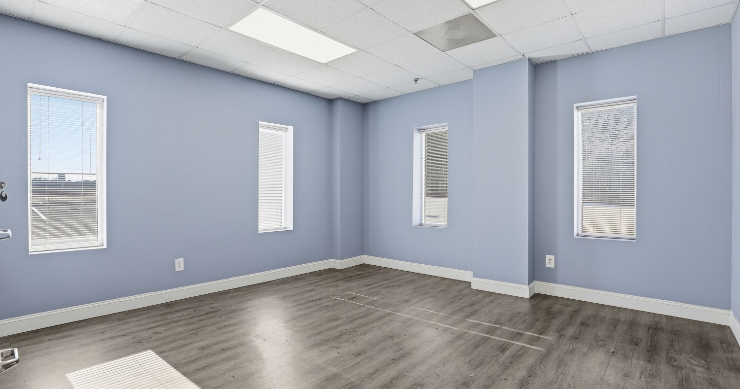 Renovated office room at 6863 NC-56 with freshly painted walls, wood-look flooring, and recessed ceiling lighting