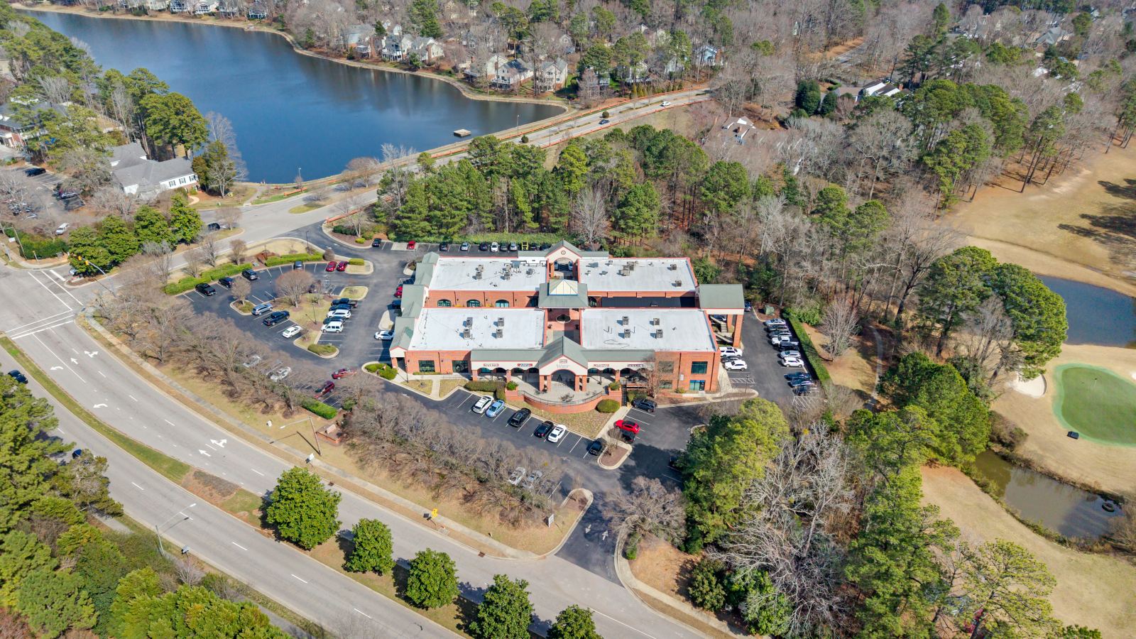 Aerial view of Lochmere Pavilion showing the full 3.83-acre site, its parking fields, frontage on Kildaire Farm Road, and the adjoining Lochmere Golf Club and lake