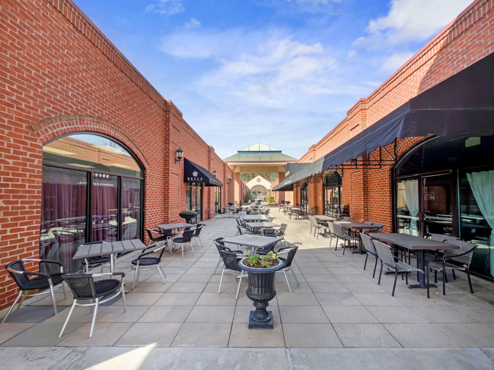 Interior courtyard at Lochmere Pavilion with cafe tables and chairs between brick storefronts under awnings