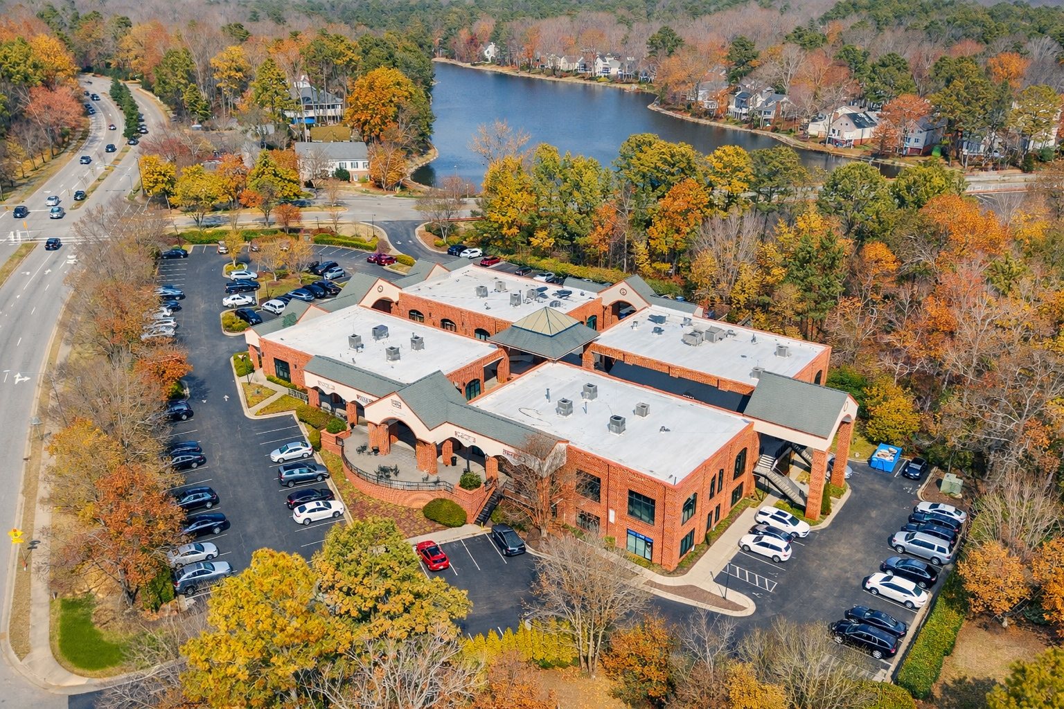Aerial view of Lochmere Pavilion, a brick neighborhood retail center at 2425 Kildaire Farm Road in Cary, North Carolina, with Lochmere Lake and surrounding neighborhoods behind it